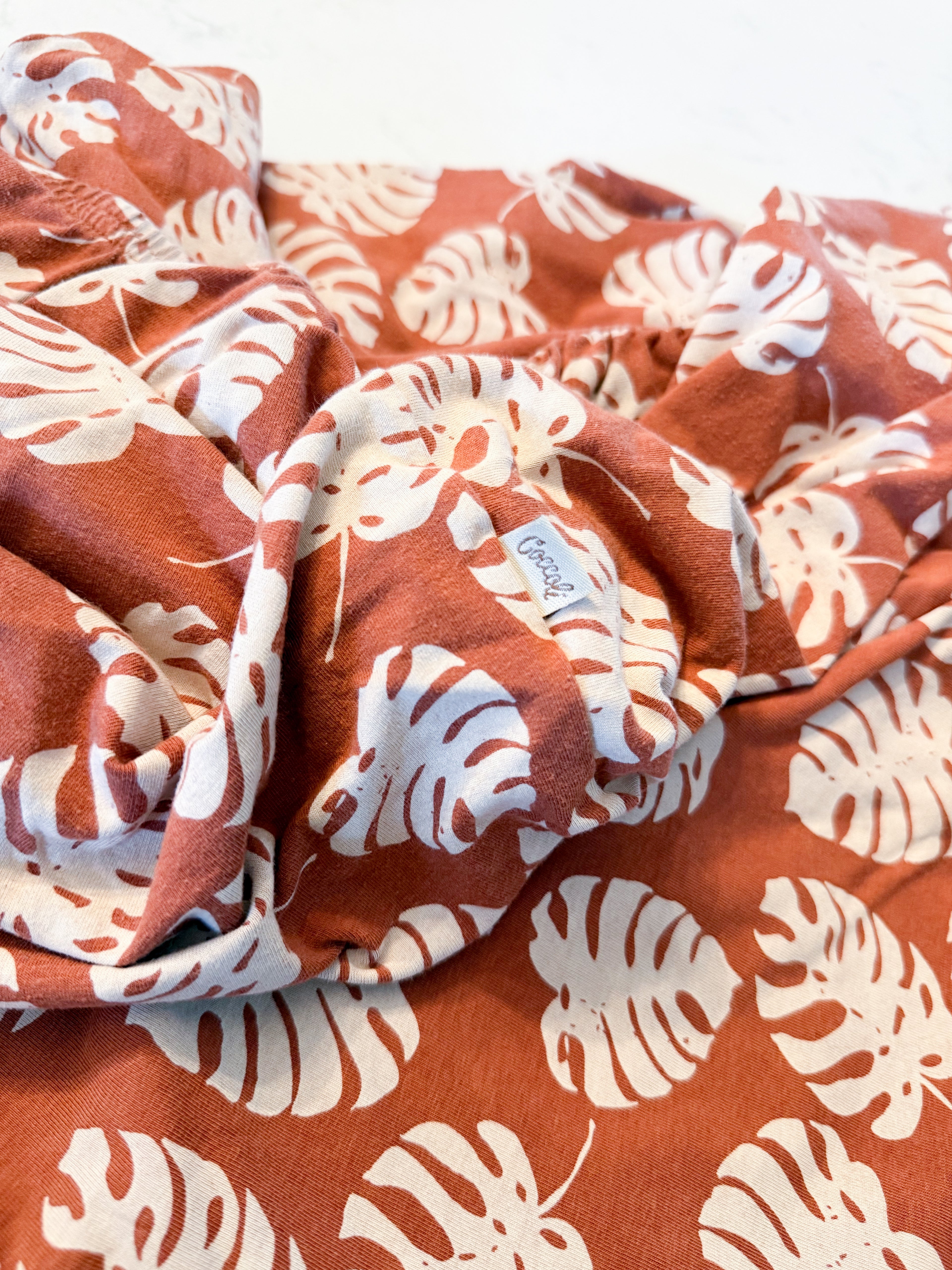Coccoli- crib sheet- GUC- brown bamboo crib sheet with neutral tropical leaves