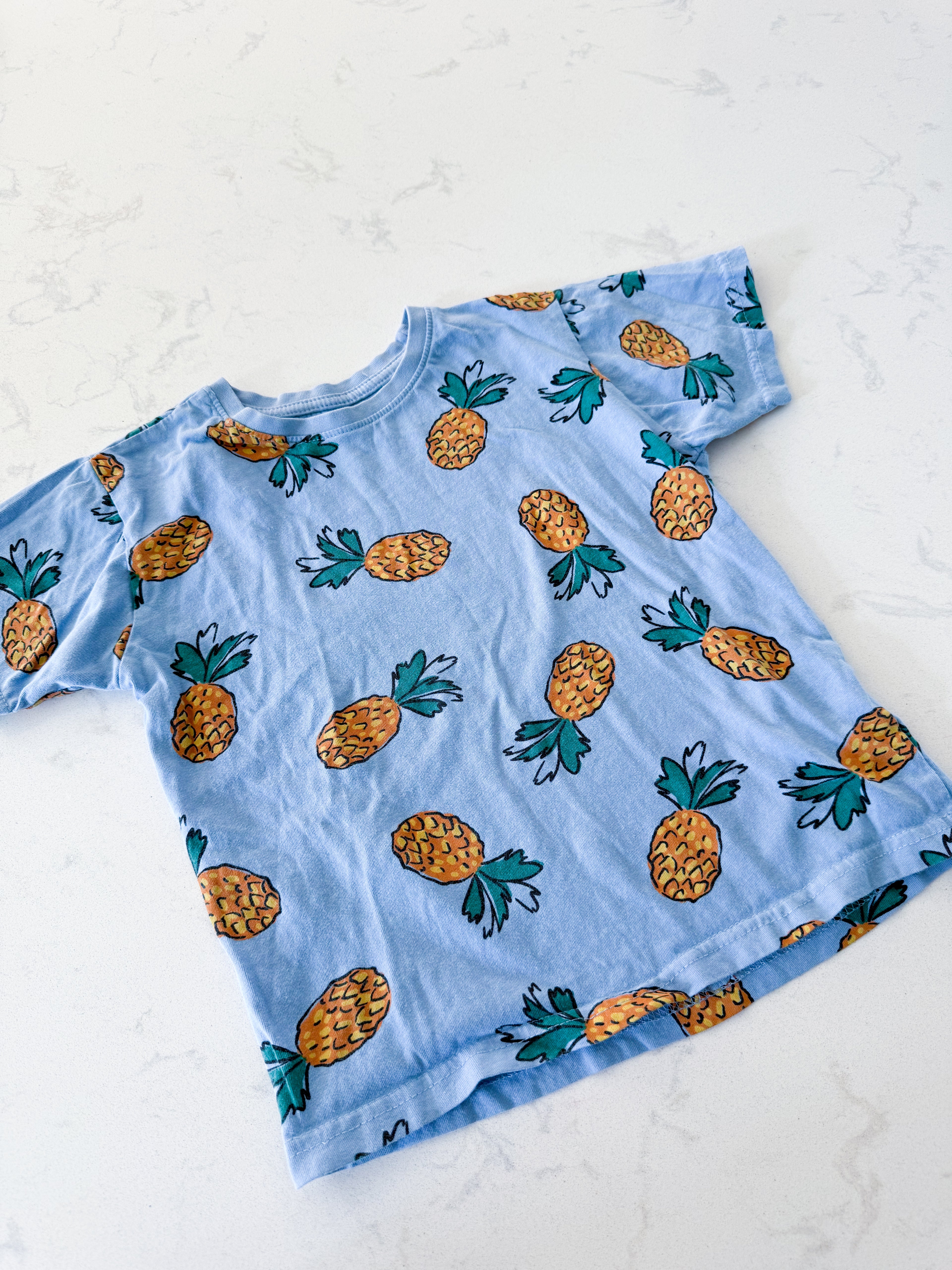 Primark- 5T- GUC- blue t shirt with pineapples all over