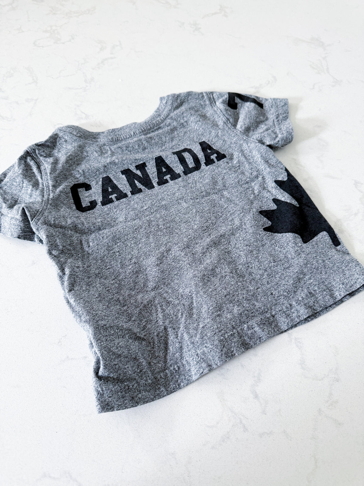 Roots- 12-18m- VGUC- Grey t shirt with black Canada graphics and black Roots logo