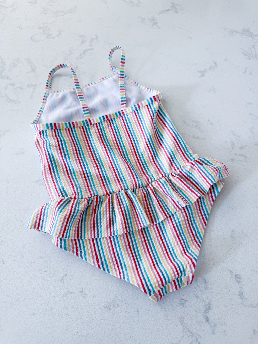 Primark- 12-18m- VGUC- rainbow coloured thin vertical striped swim suit with ruffle skirt