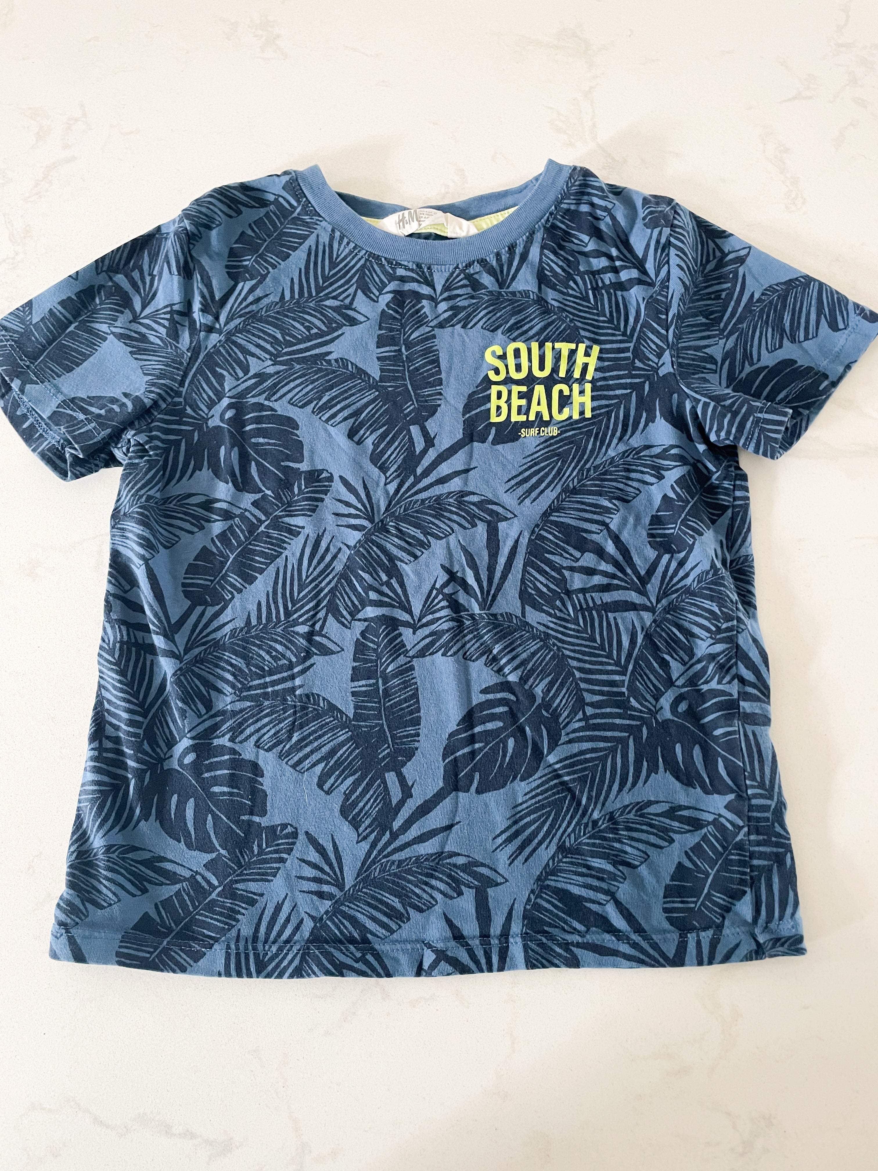 H&M- 2-4Y- VGUC- blue shirt with blue palm leaves and green writing