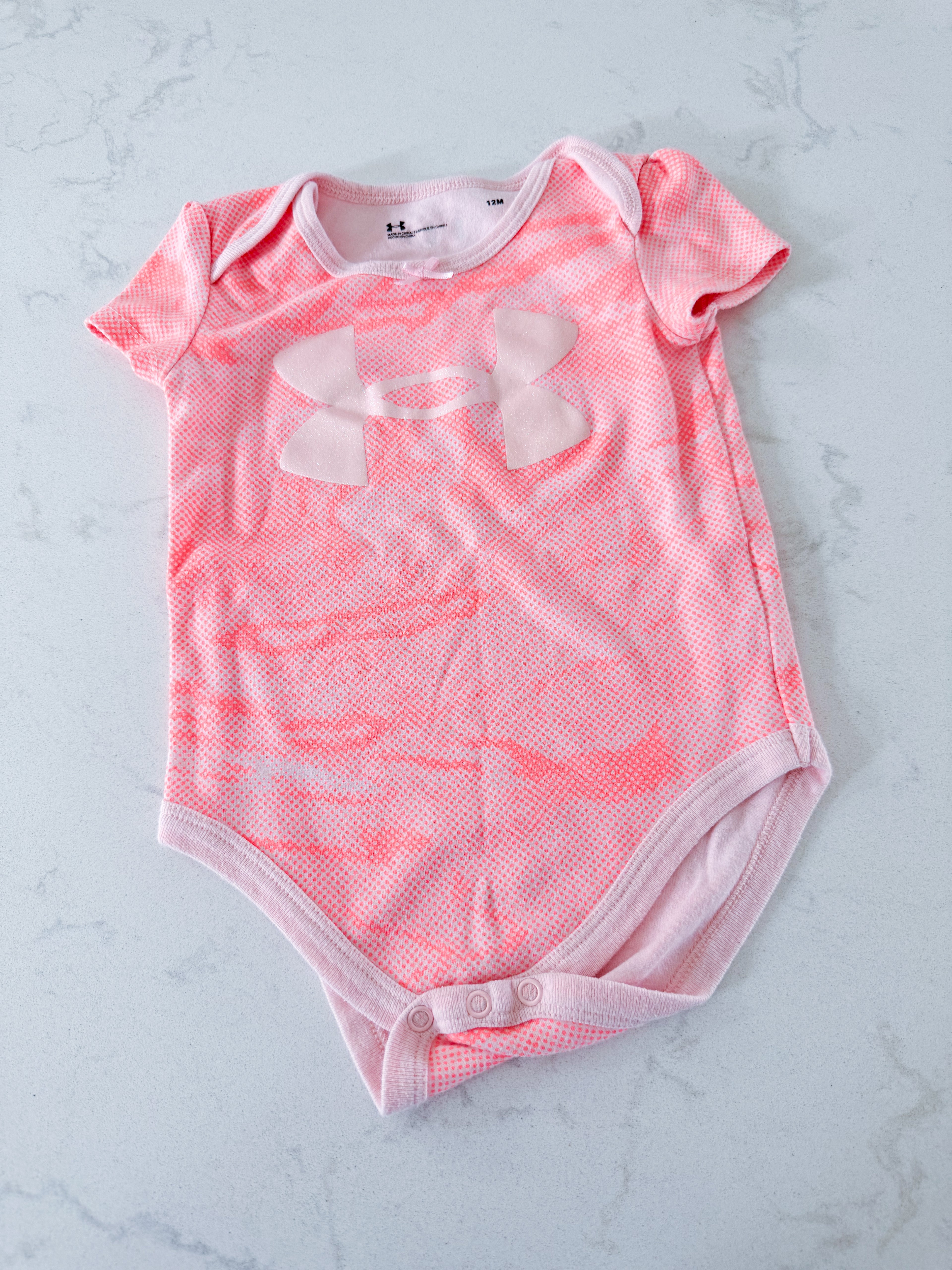 Under Armour- 12-18m- VGUC- bright pink spotted short sleeve bodysuit with sparkles