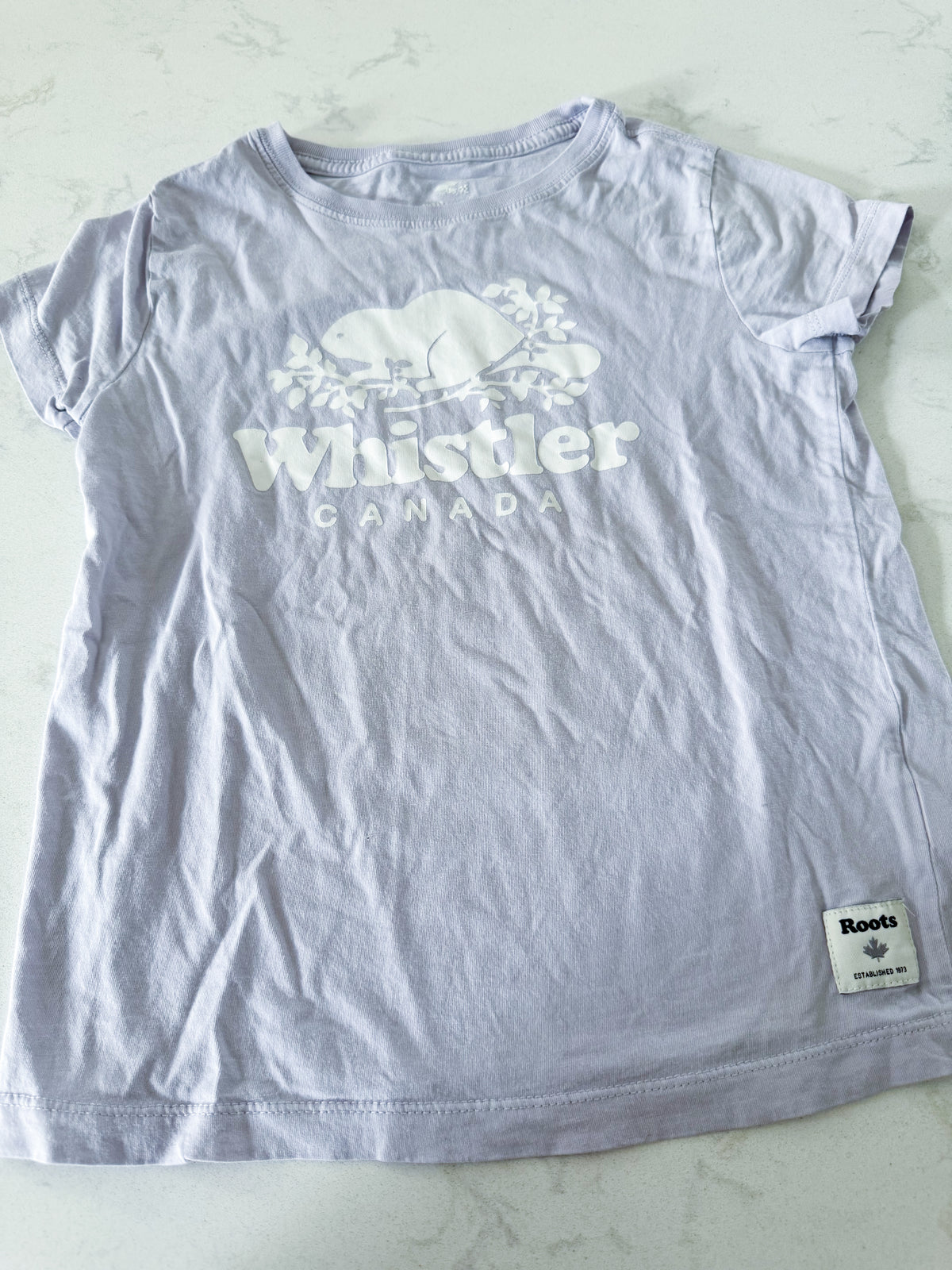 Roots- 6-7Y- PLAY- light purple t shirt with Whistler Roots logo