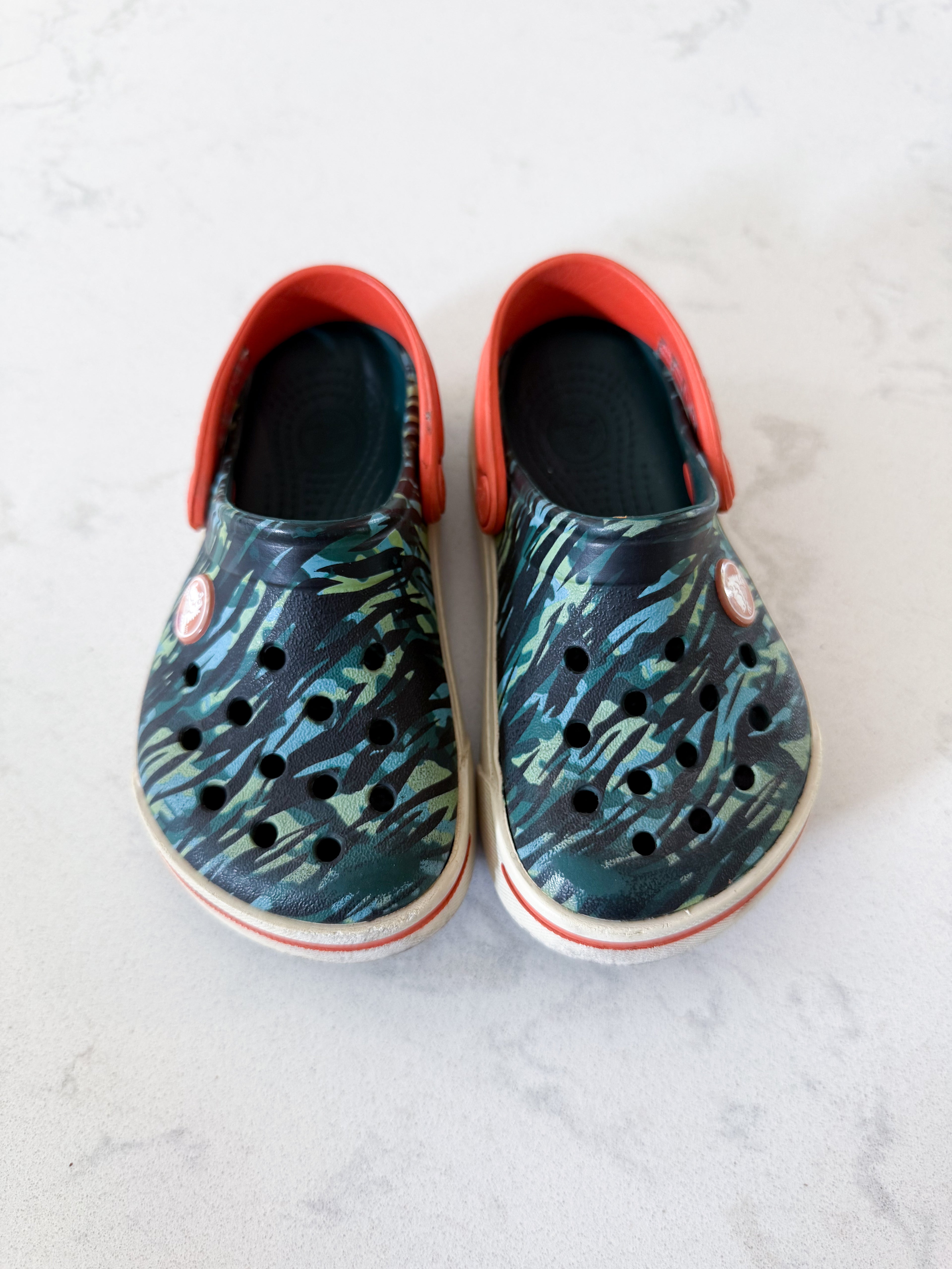Crocs- 8/9C- GUC- camo slip ons with orange accents