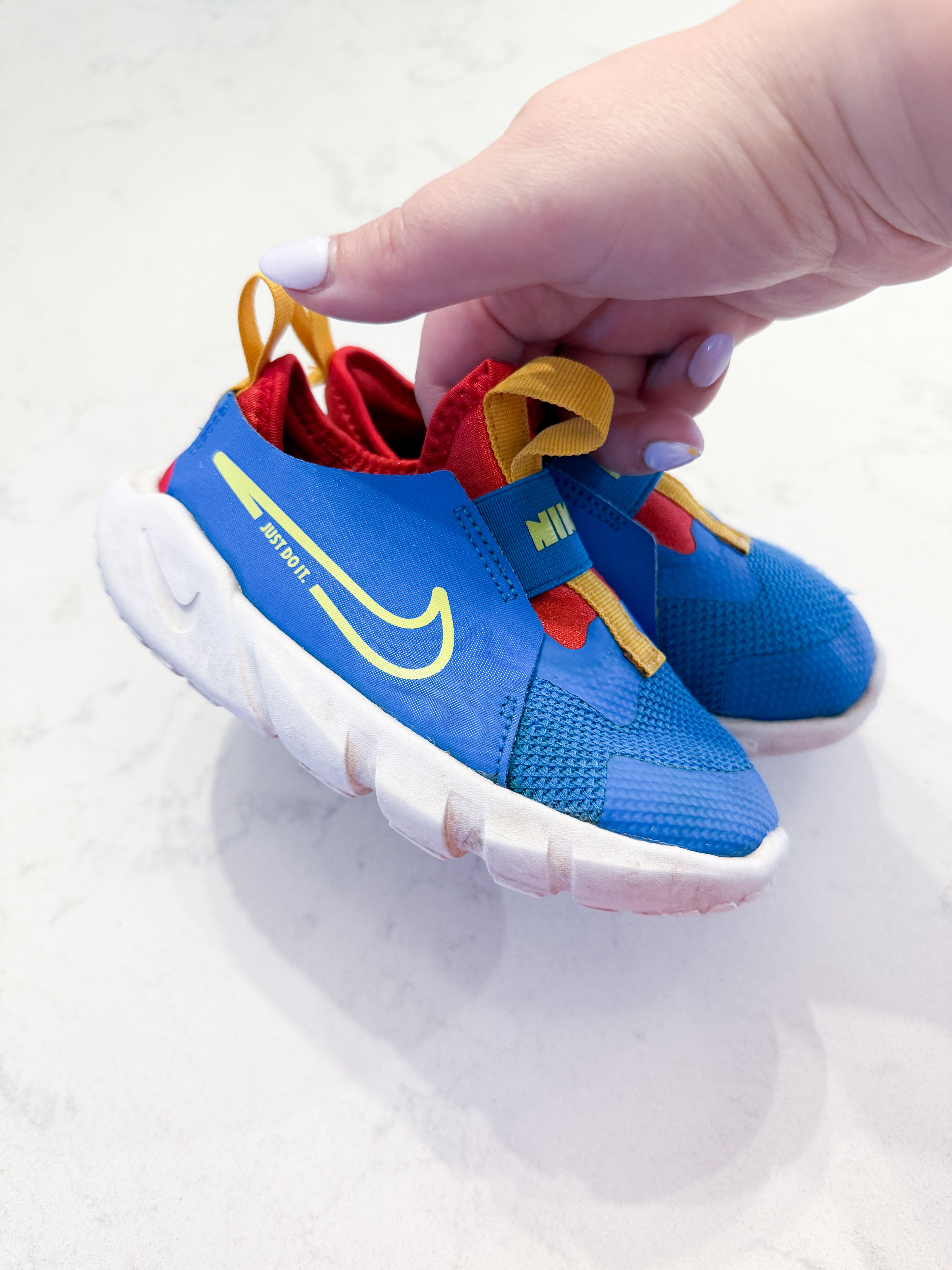 Nike- 9C- PLAY- blue slip on Nike shoes with red and yellow accents