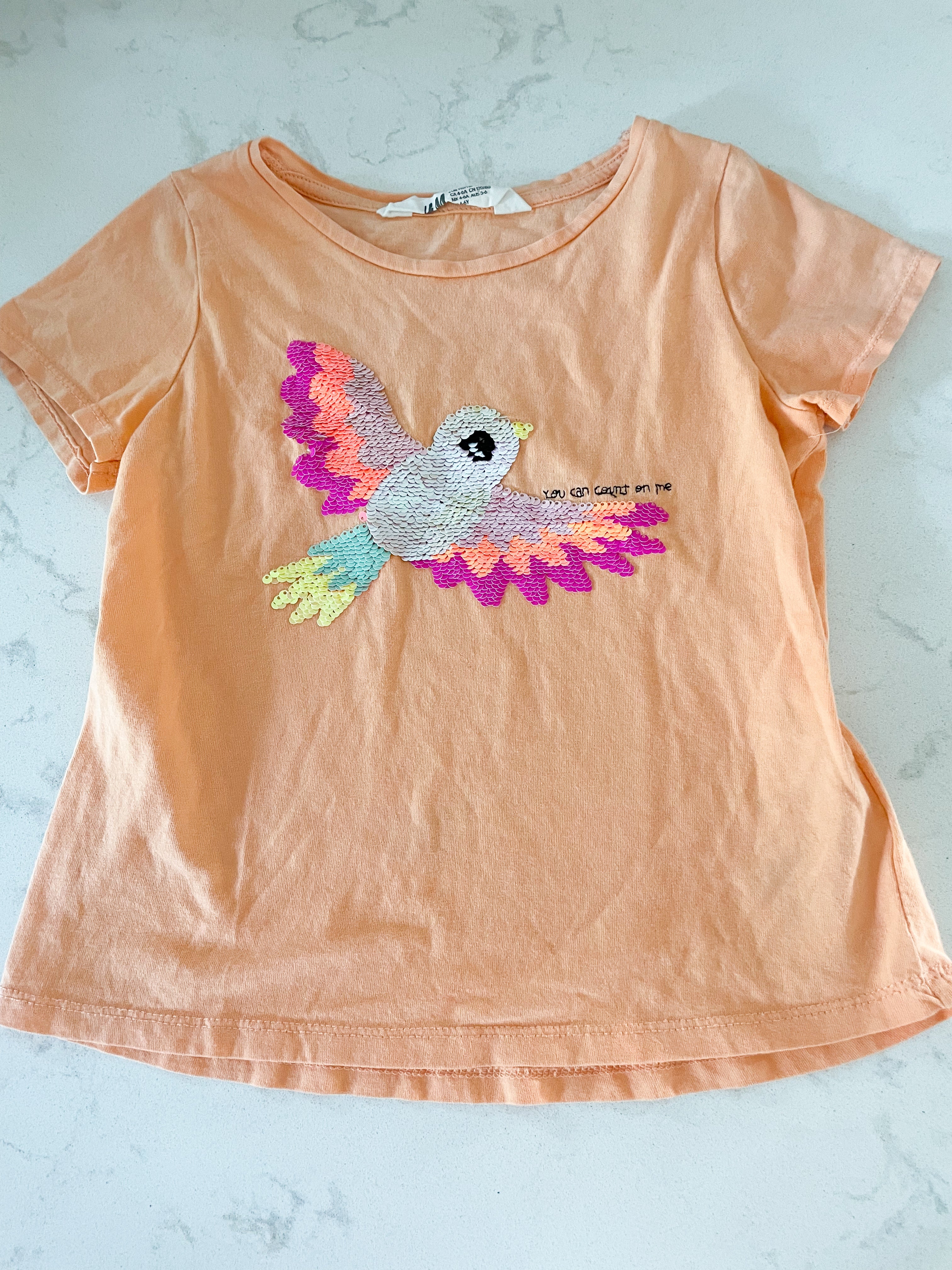 H&M- 5T/6Y- VGUC- light orange t shirt with sequin tropical bird