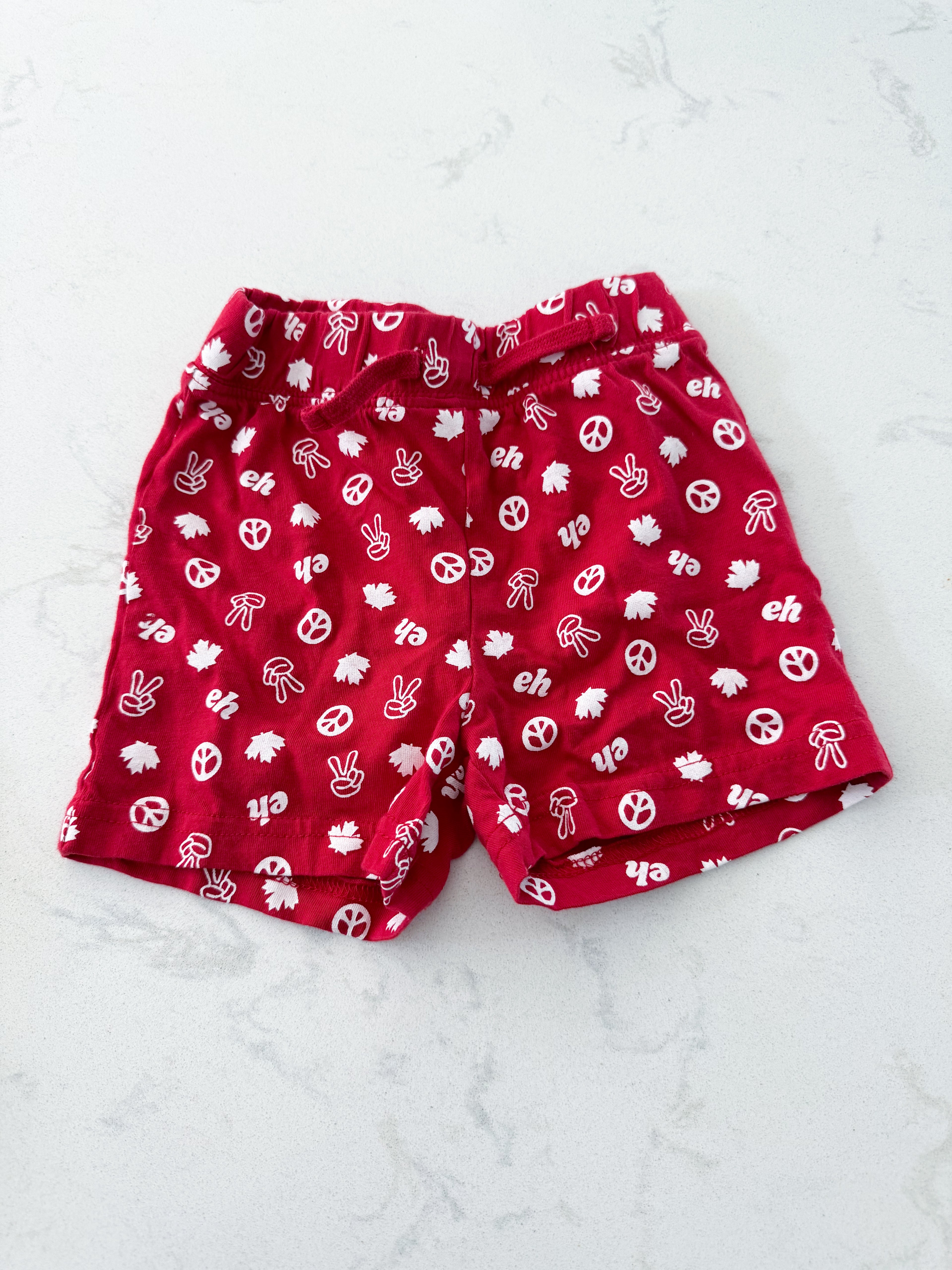 Joe fresh- 6-12m- VGUC- red shorts with Canada and peace symbols pattern