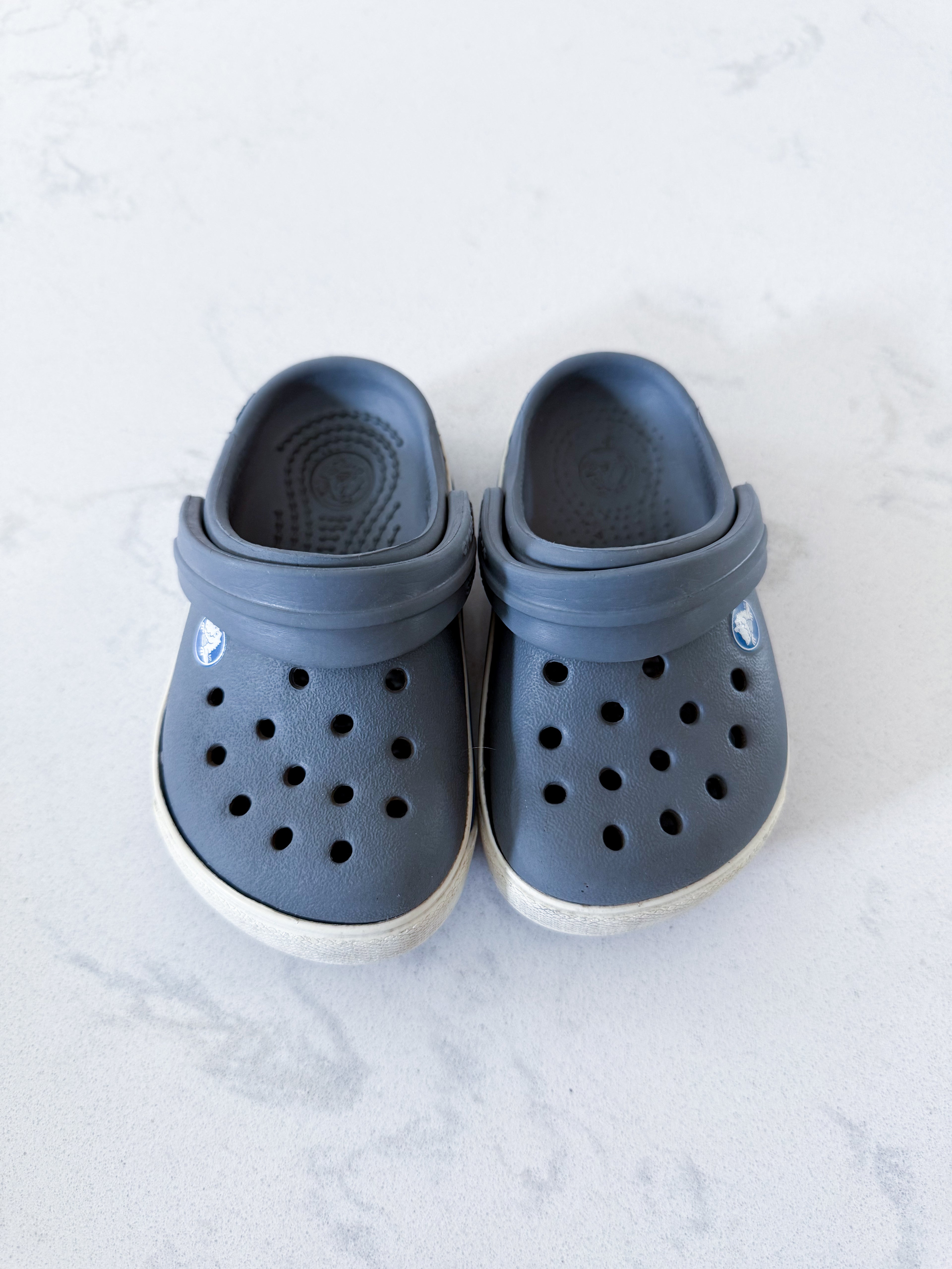 Crocs- 4/5C- GUC- grey slip on crocs with white trim