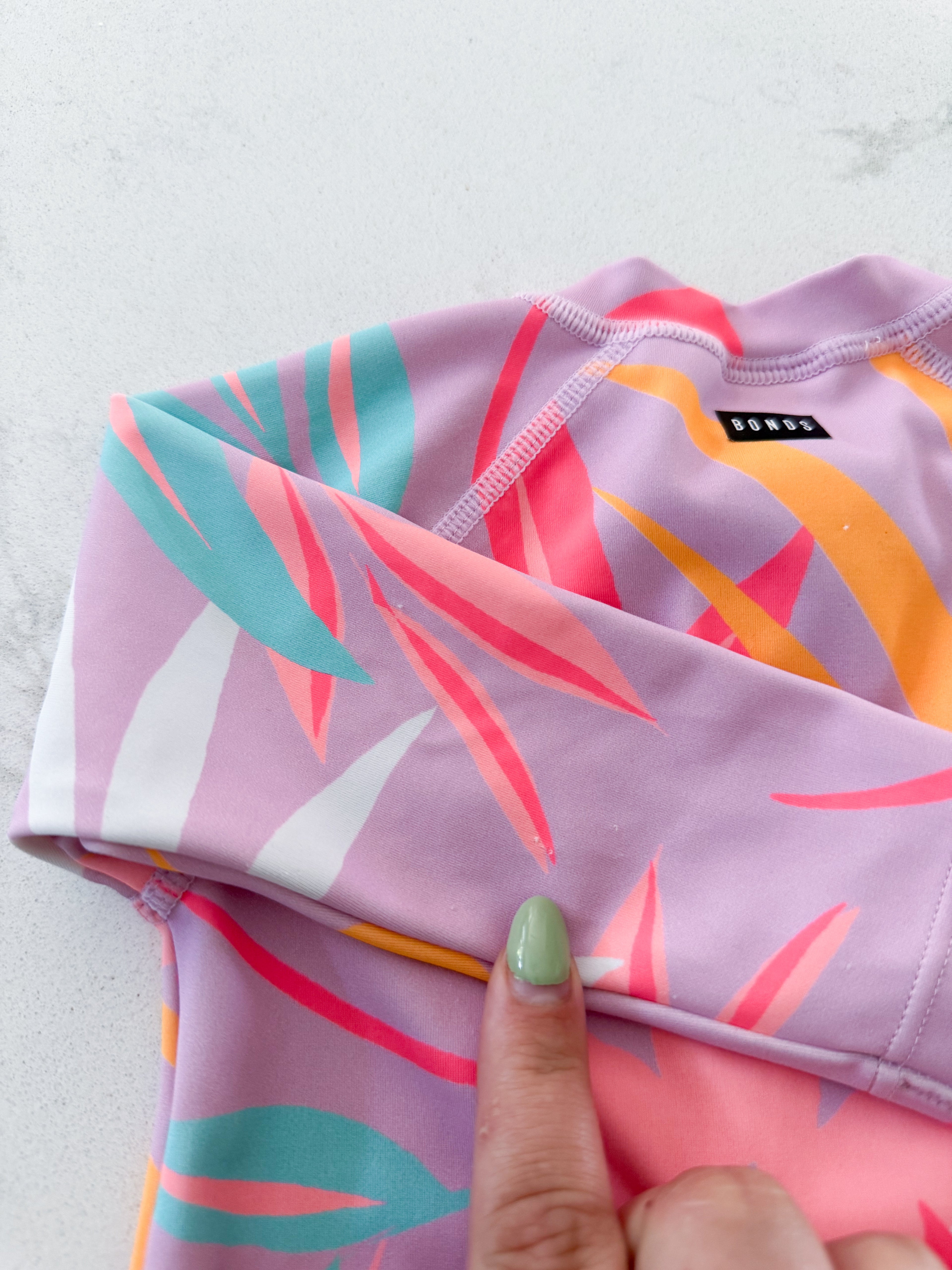 BONDS- size 00 (3-6m)- GUC- pink long sleeve swim suit with bright tropical leaves