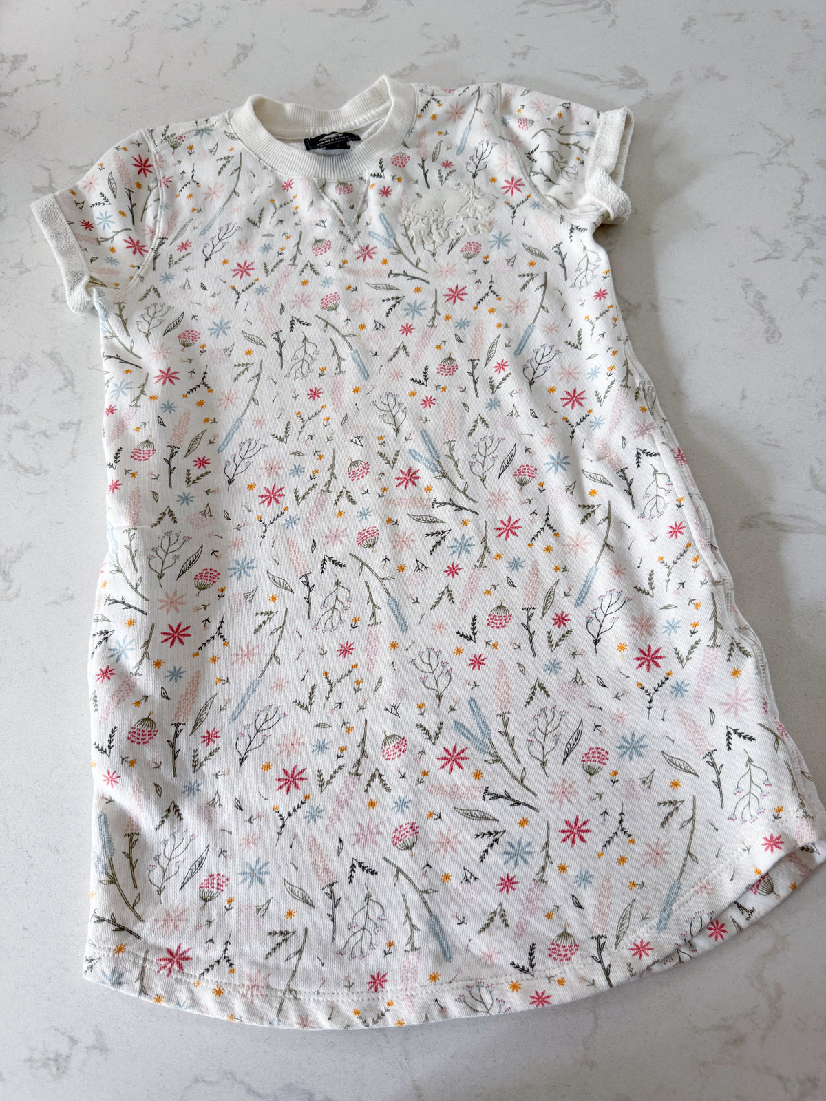 Roots- 9-10Y- VGUC- White short sleeve sweater dress with multicoloured wildflower pattern and white Roots logo
