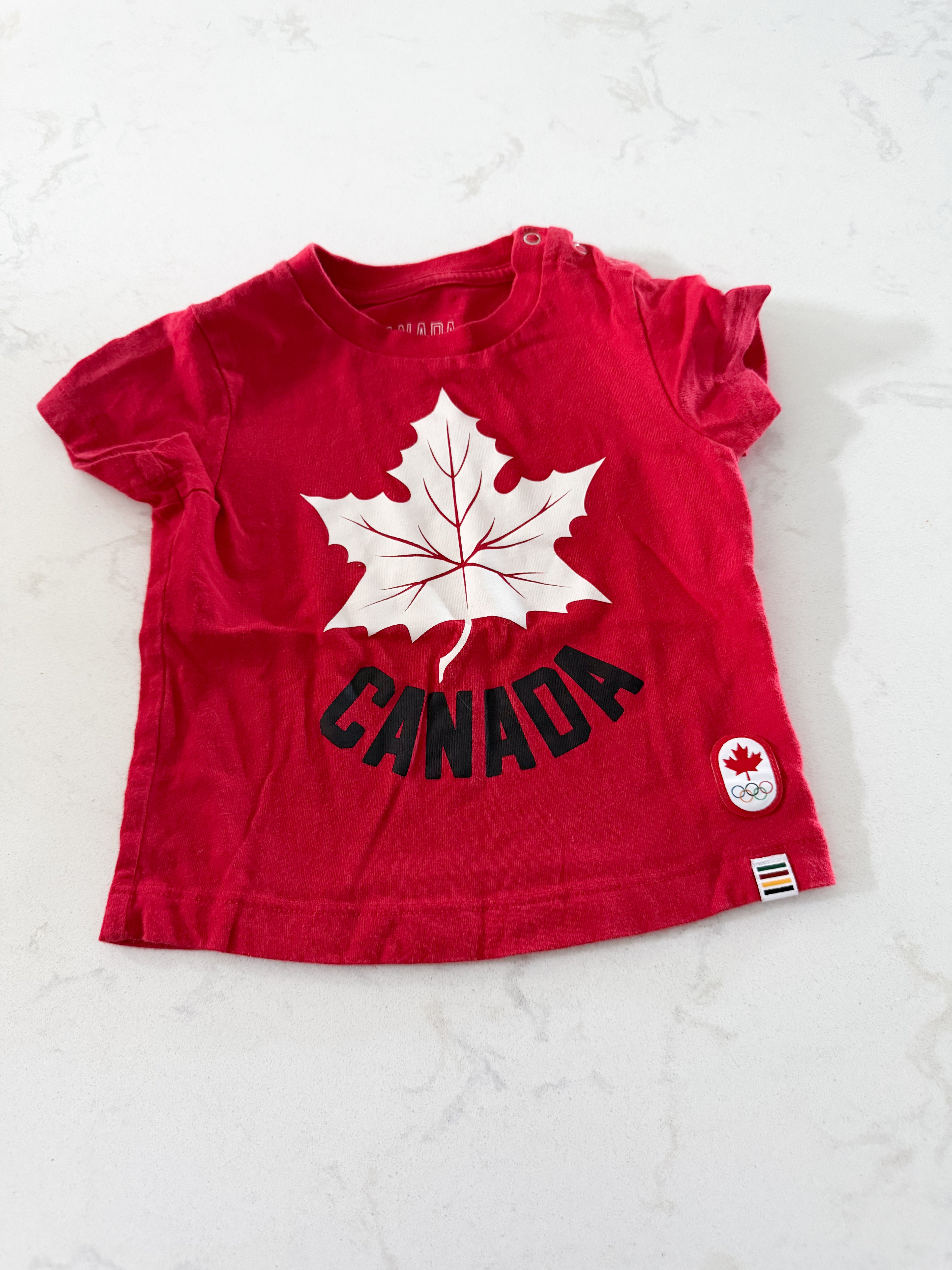 HBC- 3-6m- GUC- red t shirt with Canada graphic on front