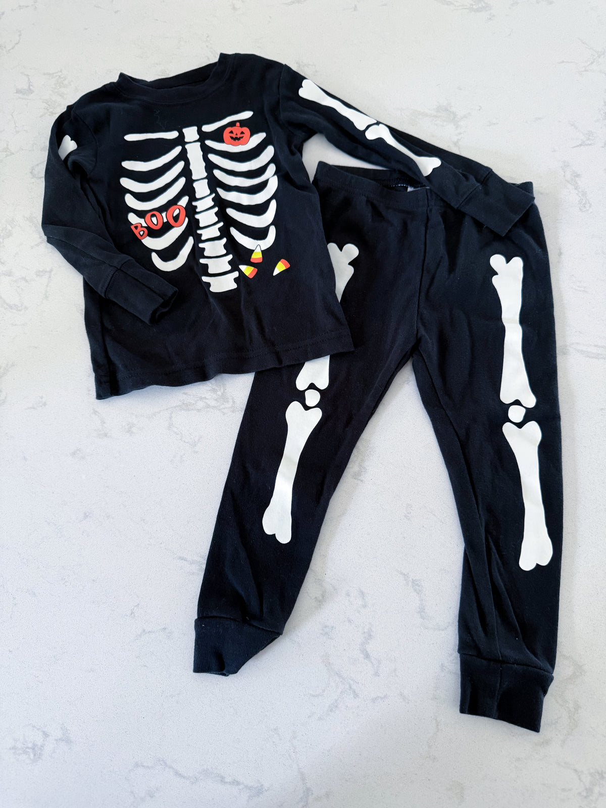 Carters- 18m- GUC- long sleeve black jammies with skeleton halloween graphic