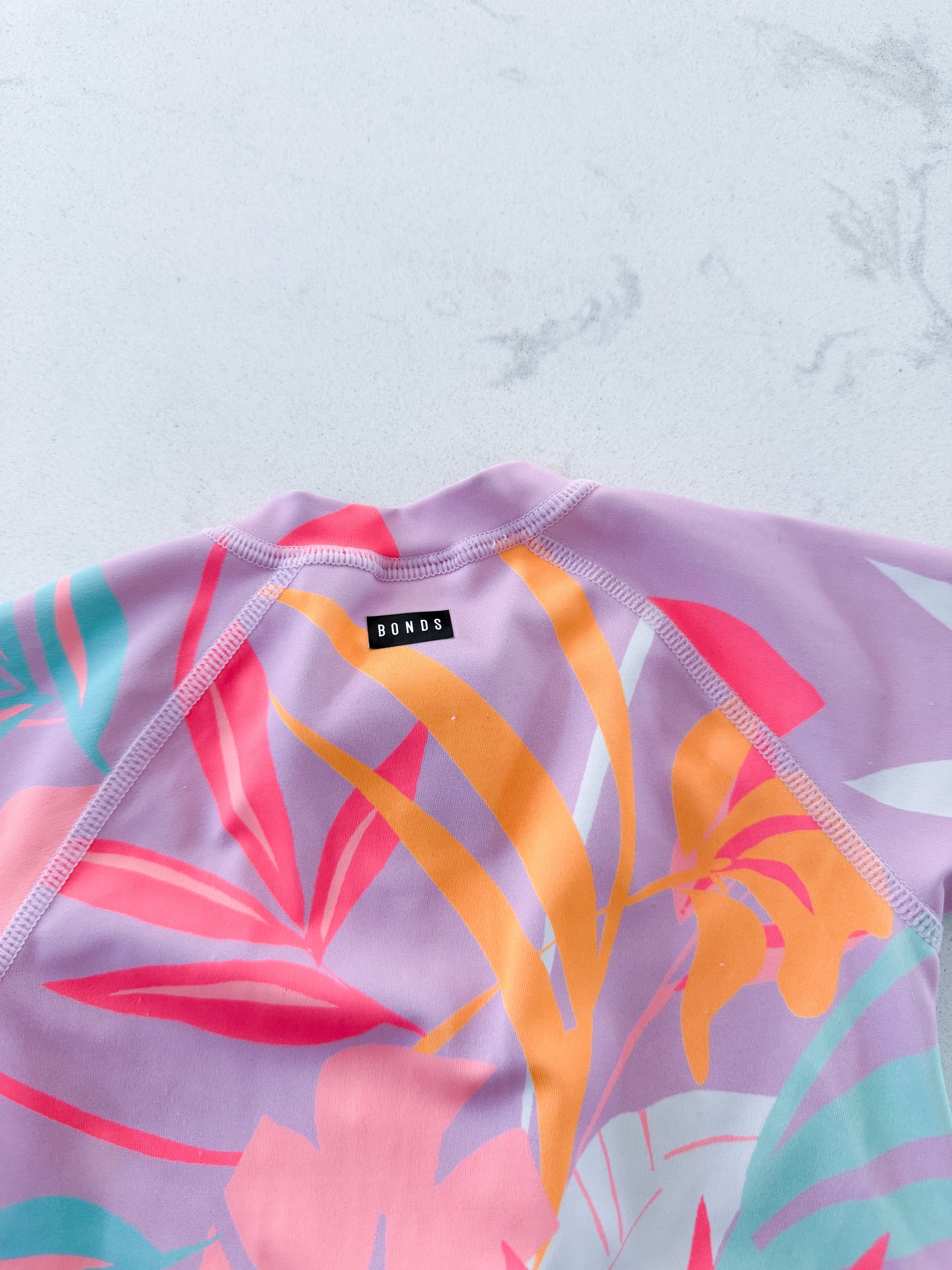BONDS- size 00 (3-6m)- GUC- pink long sleeve swim suit with bright tropical leaves