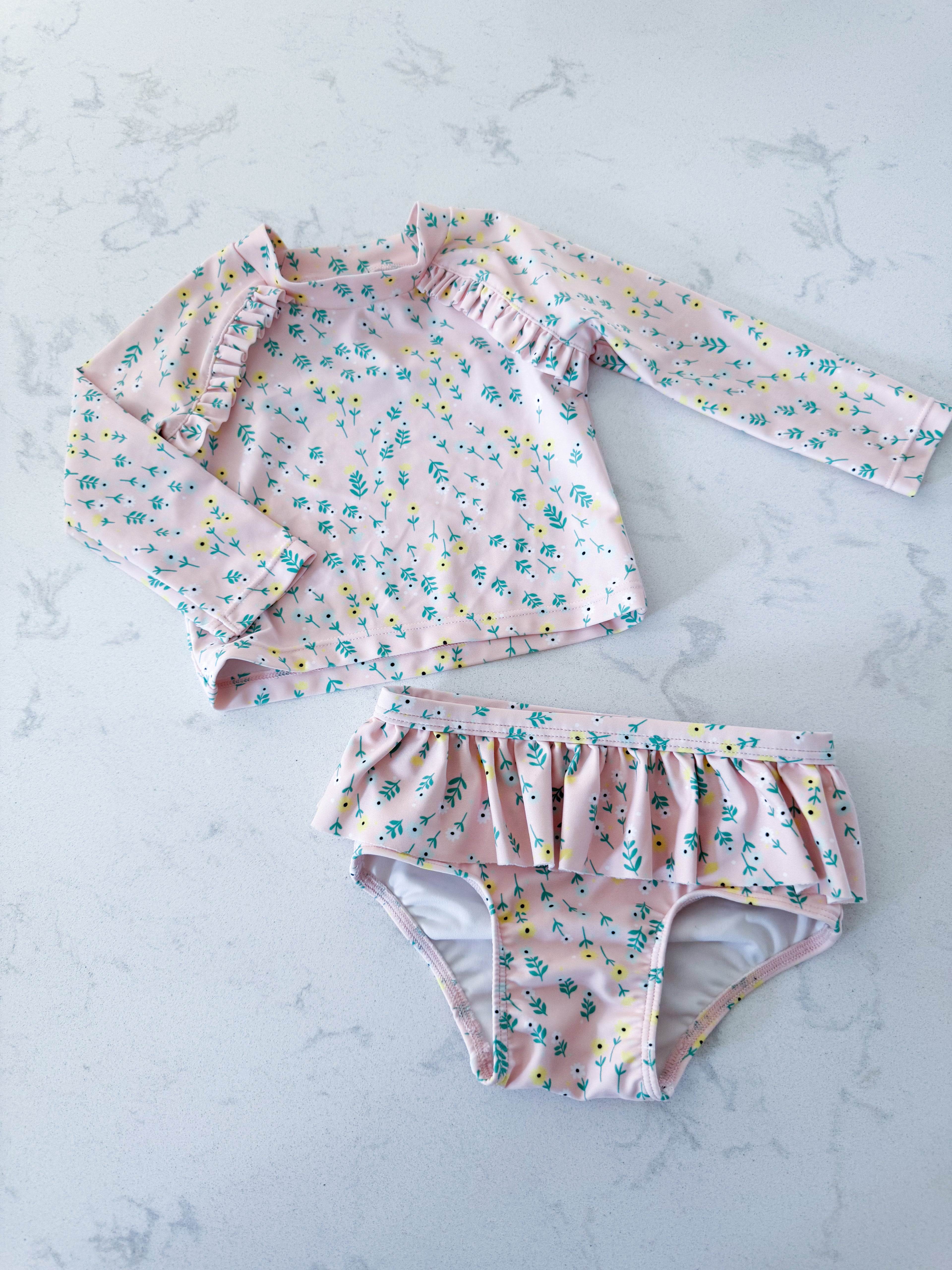 Tucker and Tate- 12m- VGUC- light pink two piece swim suit with ruffle skirt and yellow and light blue minimalist floral pattern