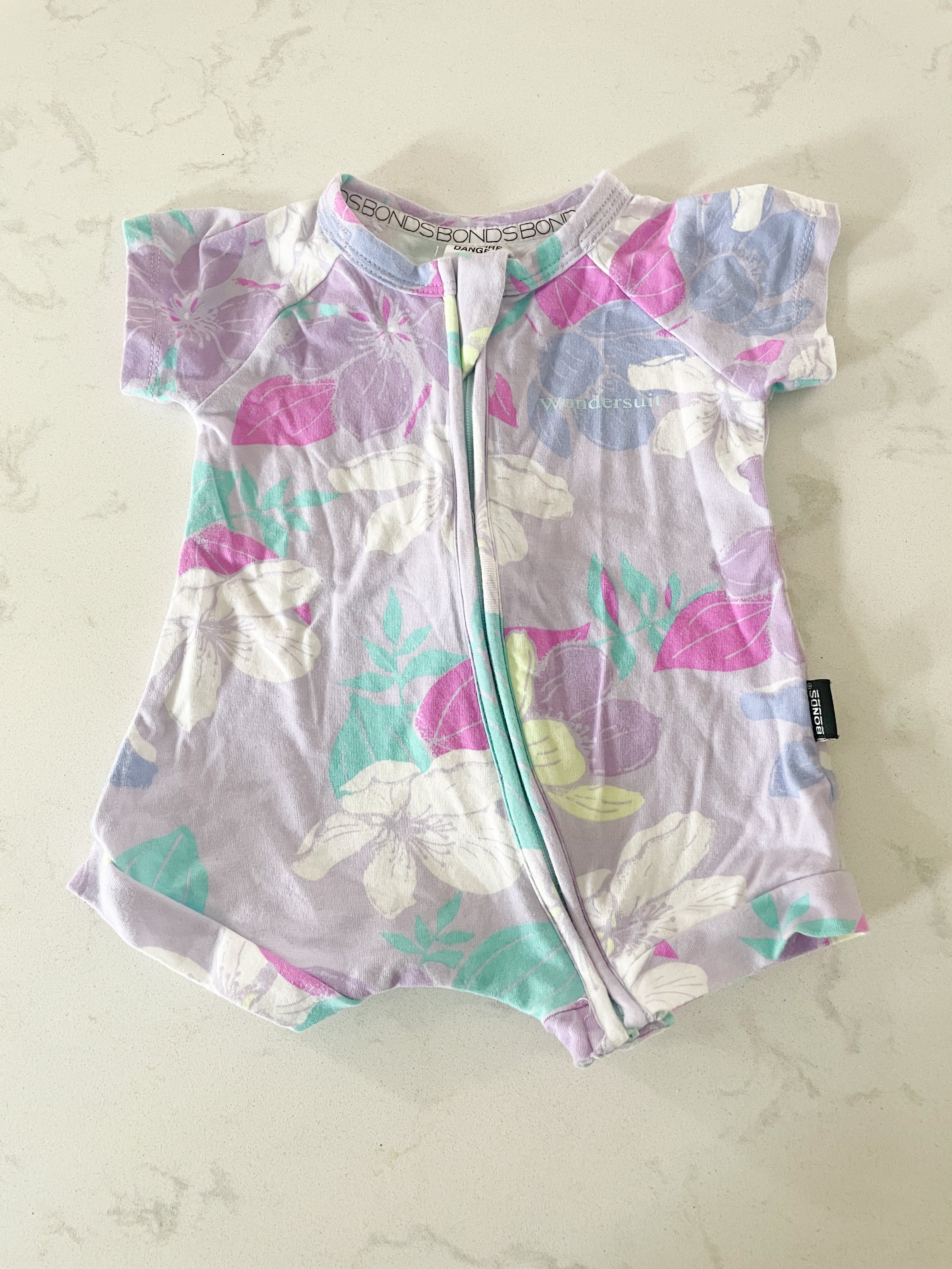BONDS- size 000 (0-3 months)- wondersuit shorts romper purple with tropical florals